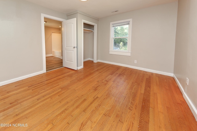 unfurnished bedroom with a closet and light hardwood / wood-style floors