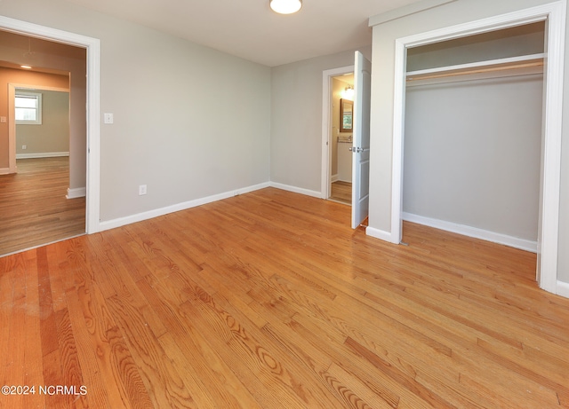 unfurnished bedroom with light hardwood / wood-style floors and a closet