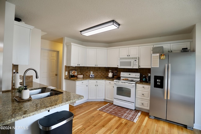 kitchen featuring white cabinets, sink, white appliances, light stone countertops, and light hardwood / wood-style floors