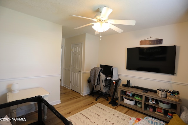 living room with light hardwood / wood-style flooring and ceiling fan