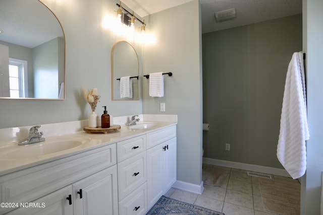 bathroom featuring vanity, toilet, tile patterned flooring, and a textured ceiling