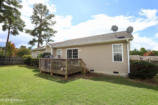 rear view of property featuring a lawn and a wooden deck