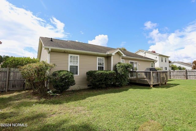 rear view of house with a deck and a lawn