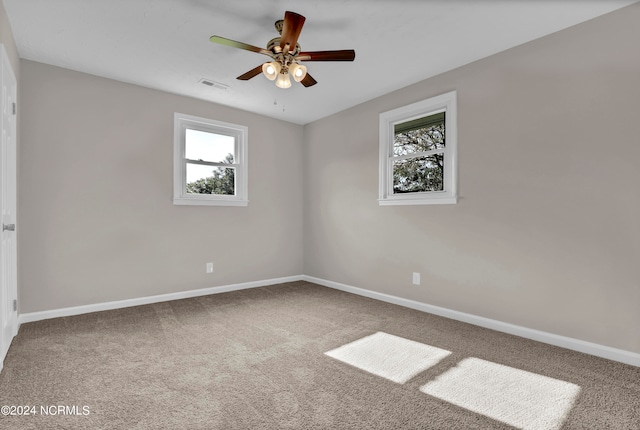 carpeted spare room featuring ceiling fan