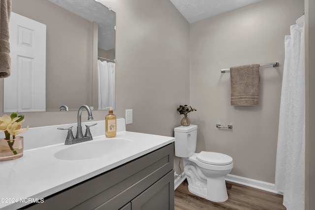 bathroom with vanity, toilet, a textured ceiling, and hardwood / wood-style flooring