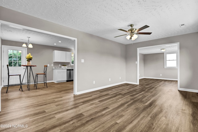 empty room featuring a textured ceiling, plenty of natural light, and hardwood / wood-style floors