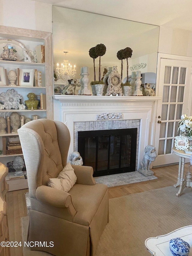 living room featuring a fireplace, hardwood / wood-style floors, and a chandelier