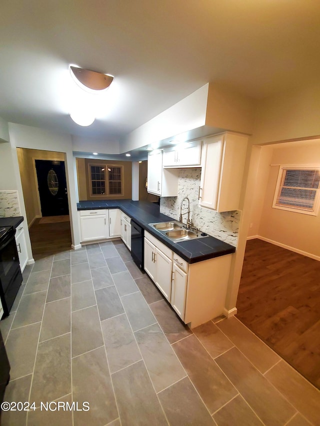 kitchen with black appliances, sink, dark hardwood / wood-style flooring, and white cabinets