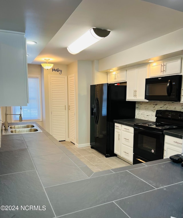 kitchen with sink, decorative backsplash, white cabinets, black appliances, and light tile patterned floors