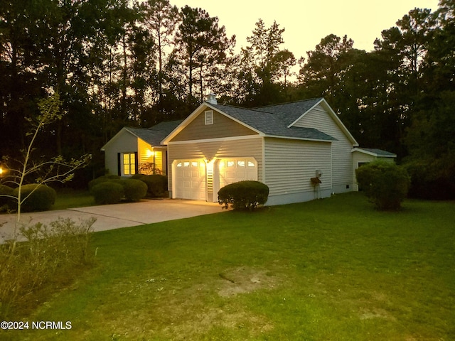 view of front facade with a garage and a lawn