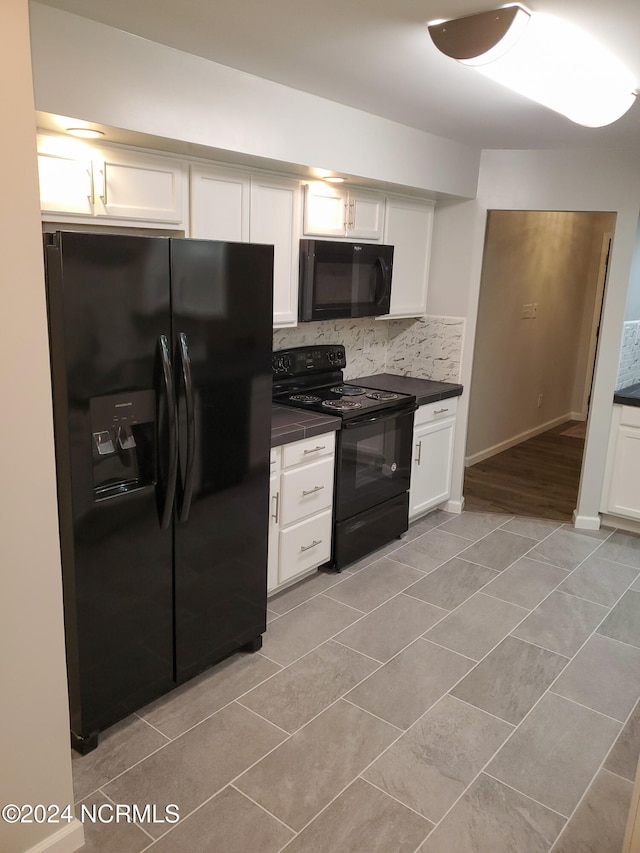 kitchen with tasteful backsplash, black appliances, and white cabinetry