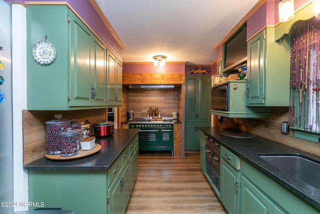 kitchen with light hardwood / wood-style flooring, green cabinets, a textured ceiling, and double oven range