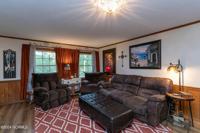 living room featuring a textured ceiling, crown molding, wooden walls, and hardwood / wood-style floors