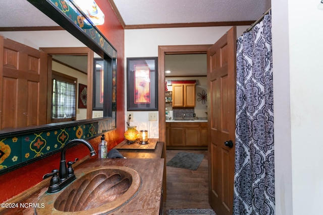 bathroom with ornamental molding, wood-type flooring, decorative backsplash, and vanity