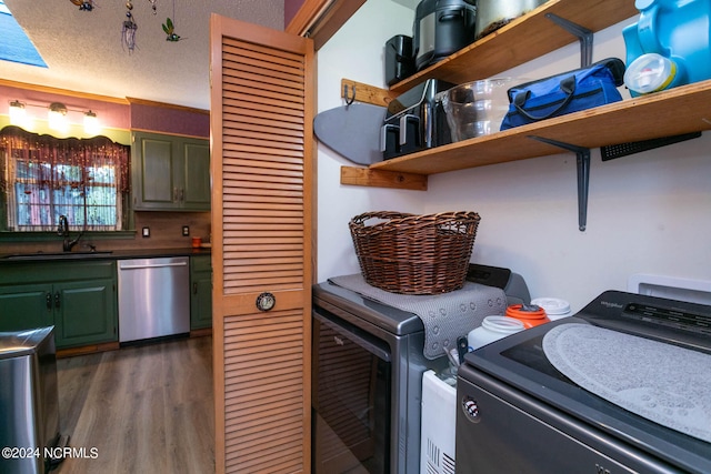 laundry area featuring a textured ceiling, dark hardwood / wood-style floors, separate washer and dryer, and sink