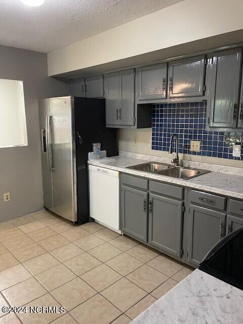 kitchen with sink, stainless steel fridge with ice dispenser, a textured ceiling, white dishwasher, and gray cabinets