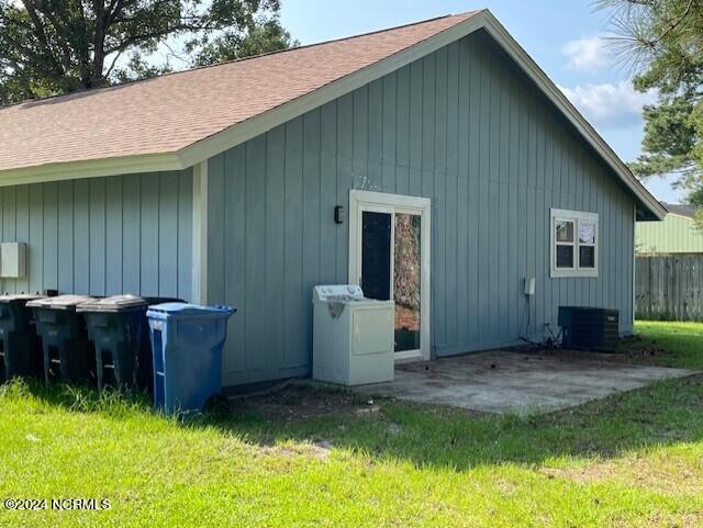 exterior space with washer / clothes dryer, cooling unit, a patio area, and a lawn