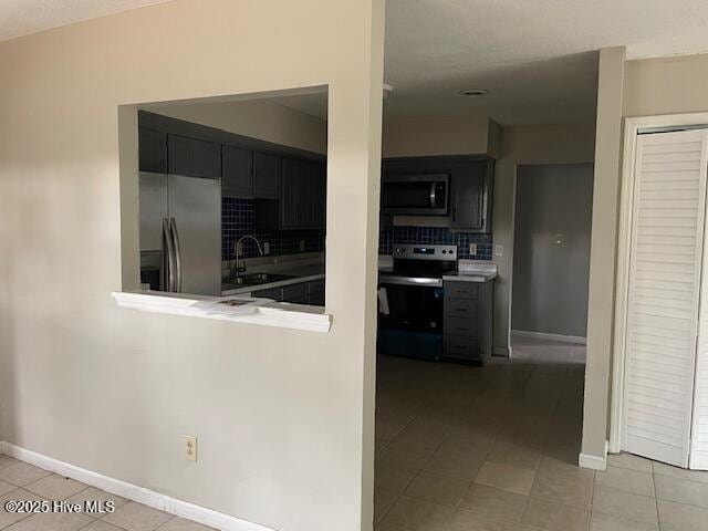 kitchen featuring electric stove, sink, tasteful backsplash, light tile patterned flooring, and stainless steel fridge with ice dispenser