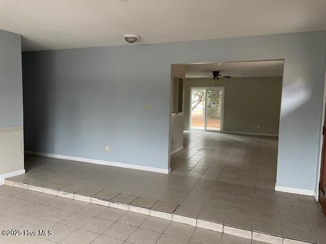 tiled empty room with ceiling fan