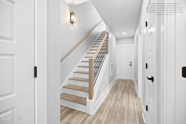 staircase with light hardwood / wood-style floors