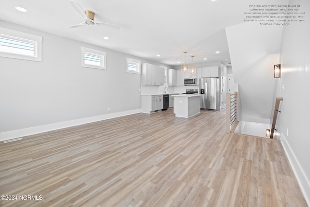 unfurnished living room featuring sink, light hardwood / wood-style flooring, and ceiling fan