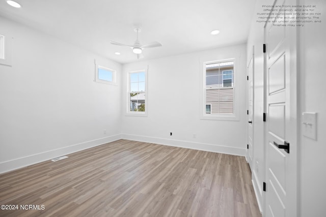 spare room with light wood-type flooring, a healthy amount of sunlight, and ceiling fan