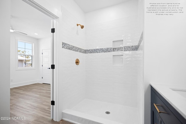 bathroom featuring vanity, tiled shower, and hardwood / wood-style floors