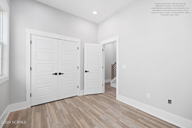 unfurnished bedroom with a closet and light hardwood / wood-style floors