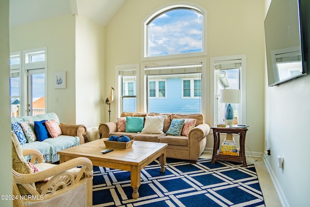 carpeted living room featuring high vaulted ceiling