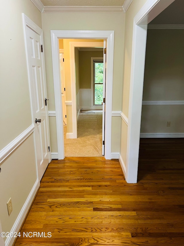 corridor featuring ornamental molding and hardwood / wood-style floors