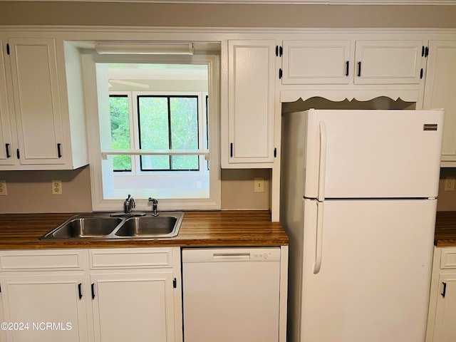 kitchen featuring white cabinets, sink, and white appliances