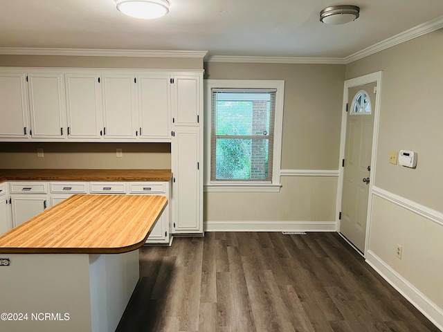 kitchen with white cabinets, ornamental molding, dark hardwood / wood-style flooring, and butcher block counters