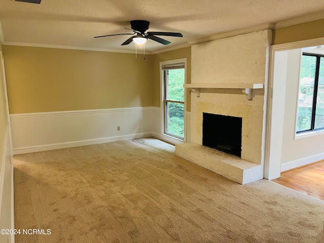 unfurnished living room with carpet, a textured ceiling, ceiling fan, and crown molding