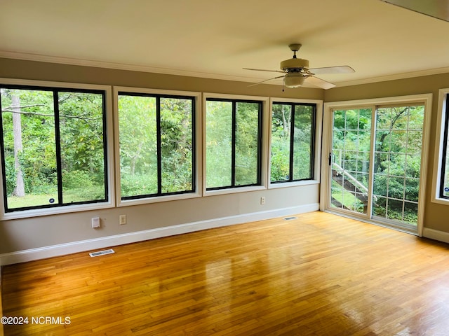 unfurnished sunroom with ceiling fan