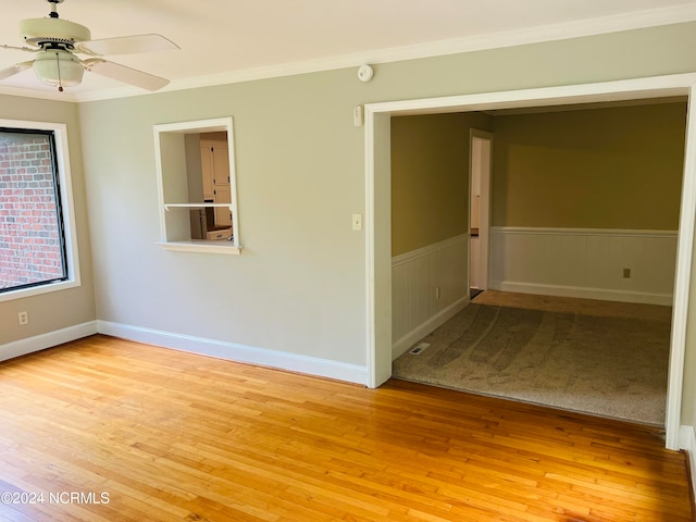 empty room featuring crown molding, light hardwood / wood-style floors, and ceiling fan