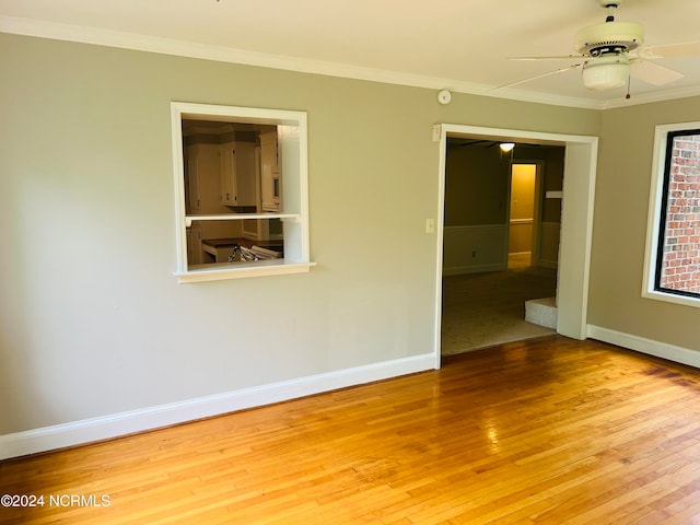 empty room featuring light hardwood / wood-style floors, ceiling fan, and crown molding