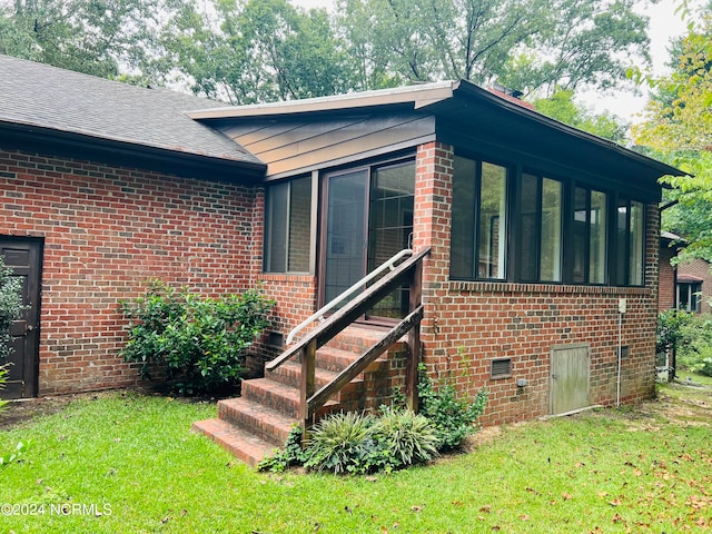 exterior space featuring a yard and a sunroom