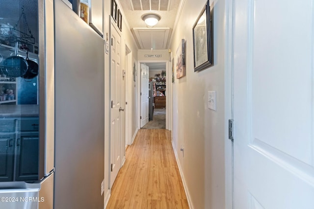 hall with a textured ceiling and light wood-type flooring