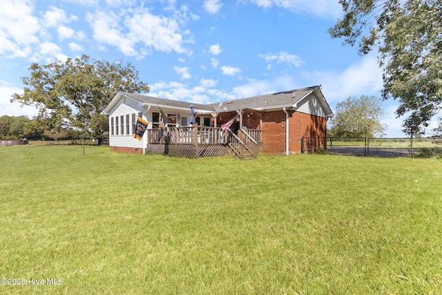 view of front of house featuring a deck, brick siding, fence, crawl space, and a front lawn