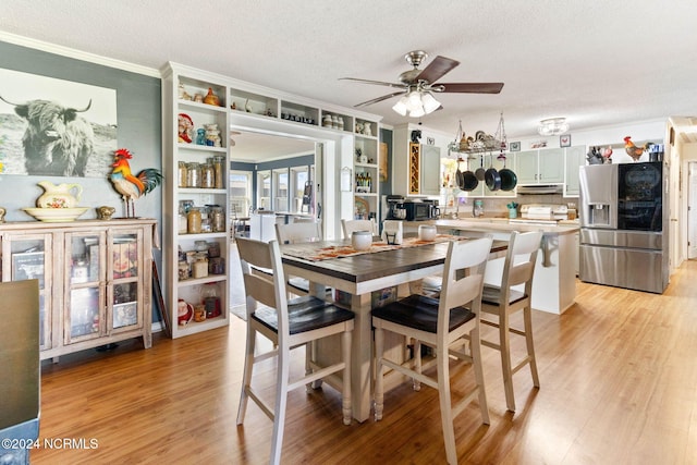 dining room with a textured ceiling, light hardwood / wood-style floors, and ceiling fan