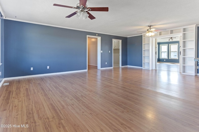 interior space with a textured ceiling, ceiling fan, wood finished floors, and baseboards