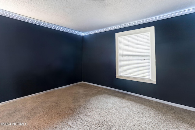 carpeted empty room featuring a textured ceiling