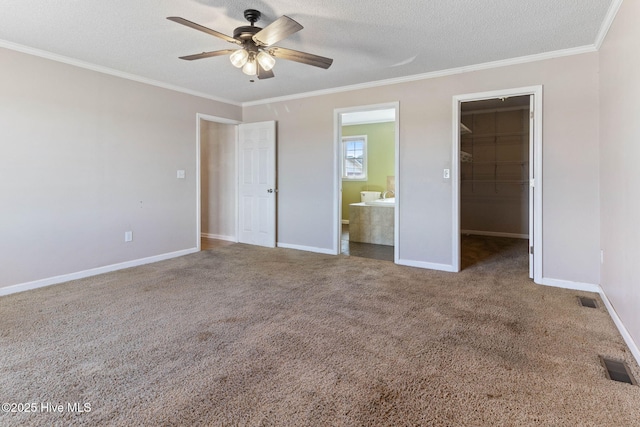 unfurnished bedroom featuring carpet, visible vents, crown molding, and a spacious closet