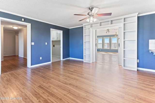 unfurnished living room with crown molding, a ceiling fan, a textured ceiling, wood finished floors, and baseboards