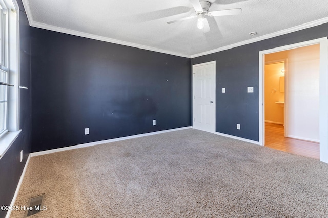 unfurnished room featuring carpet floors, baseboards, a ceiling fan, and crown molding