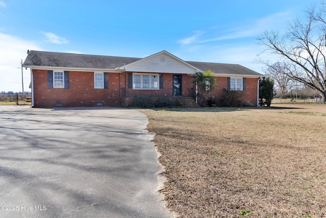 ranch-style house with brick siding, crawl space, a shingled roof, and a front lawn