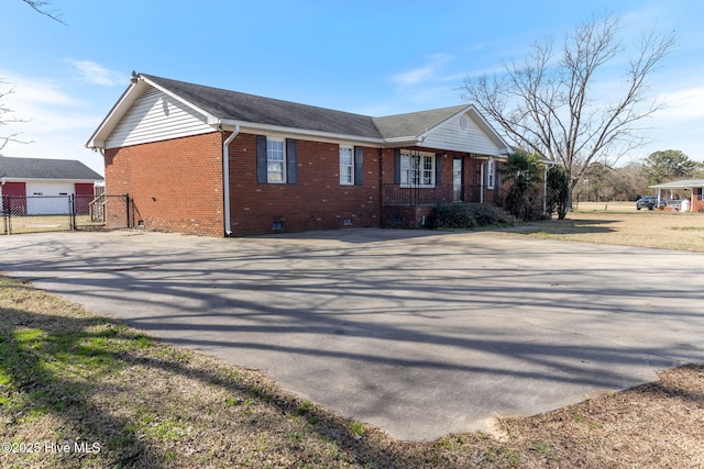 view of front of home featuring crawl space, brick siding, an outdoor structure, and fence