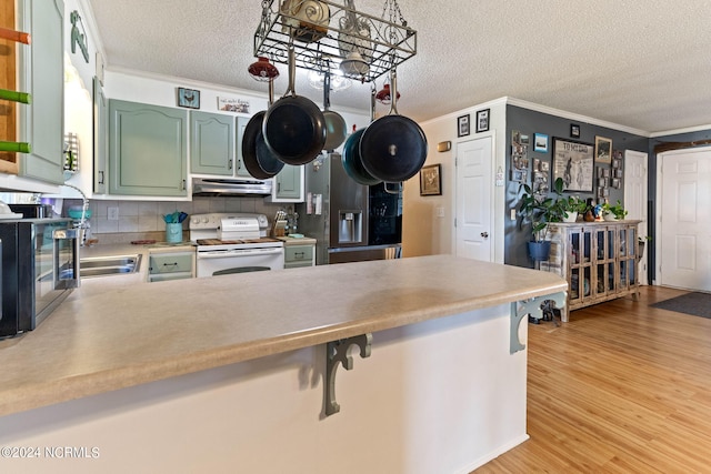 kitchen with white range, kitchen peninsula, light hardwood / wood-style floors, a textured ceiling, and green cabinetry