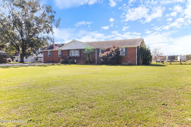 ranch-style house featuring brick siding and a front lawn