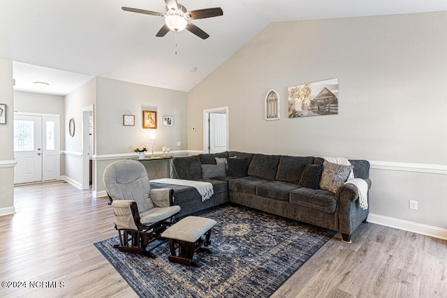 living room featuring light hardwood / wood-style flooring, lofted ceiling, and ceiling fan